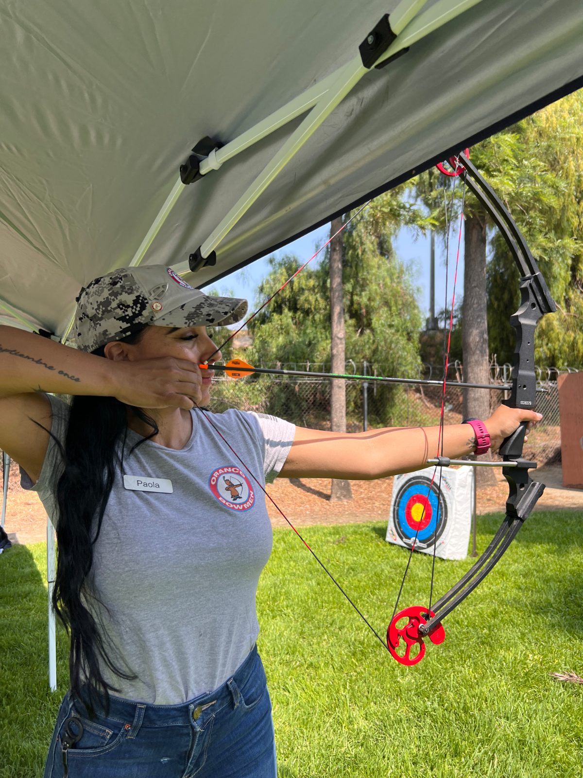 Paola shooting a bow at the archery range